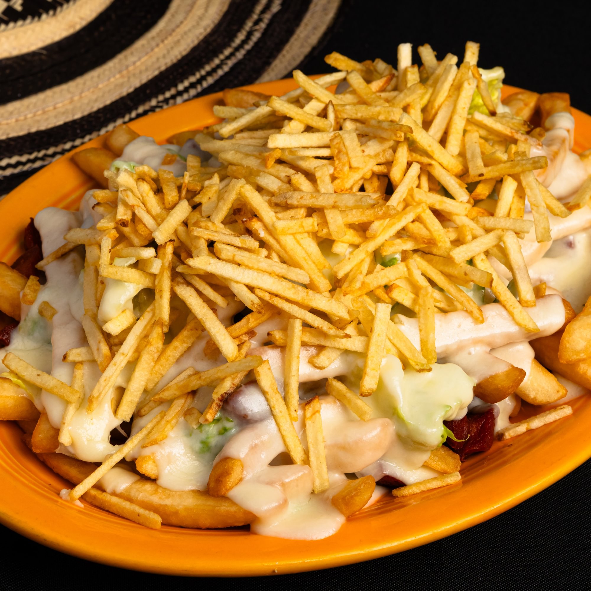 Salchipapa Costena con Queso y Salsas