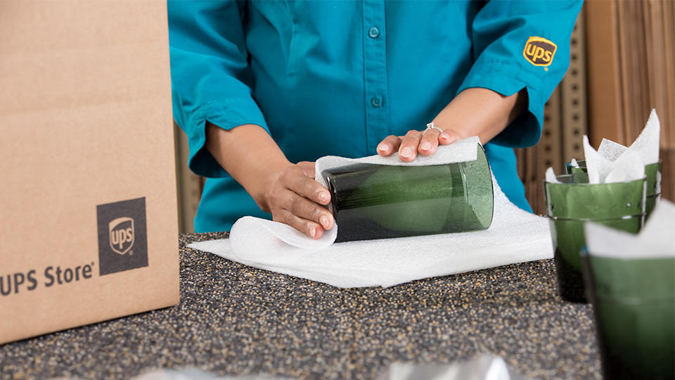 Employee wrapping and packing glassware