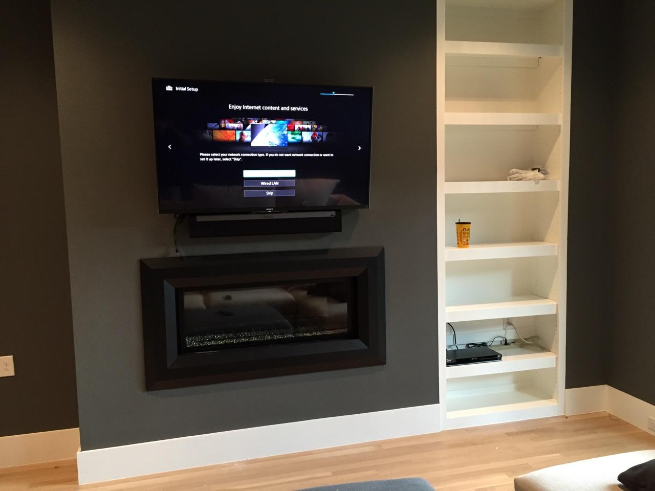 Flat screen mounted above the fireplace with SONOS sound bar.  In progress photo.