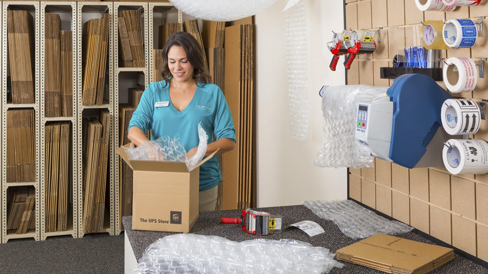 Employee packing item in a box using inflatable air cushions