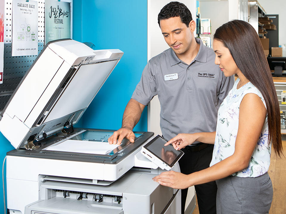 store associate helping customer make a copy inside The UPS Store