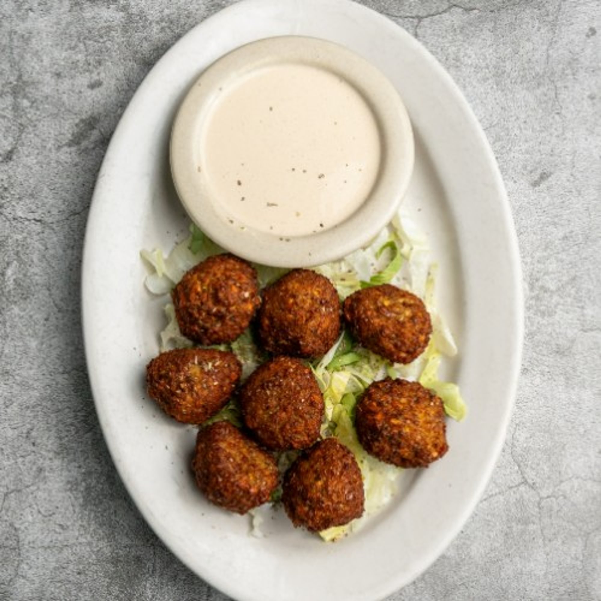 Falafel Sandwich Served with Tahini Sauce and a Side