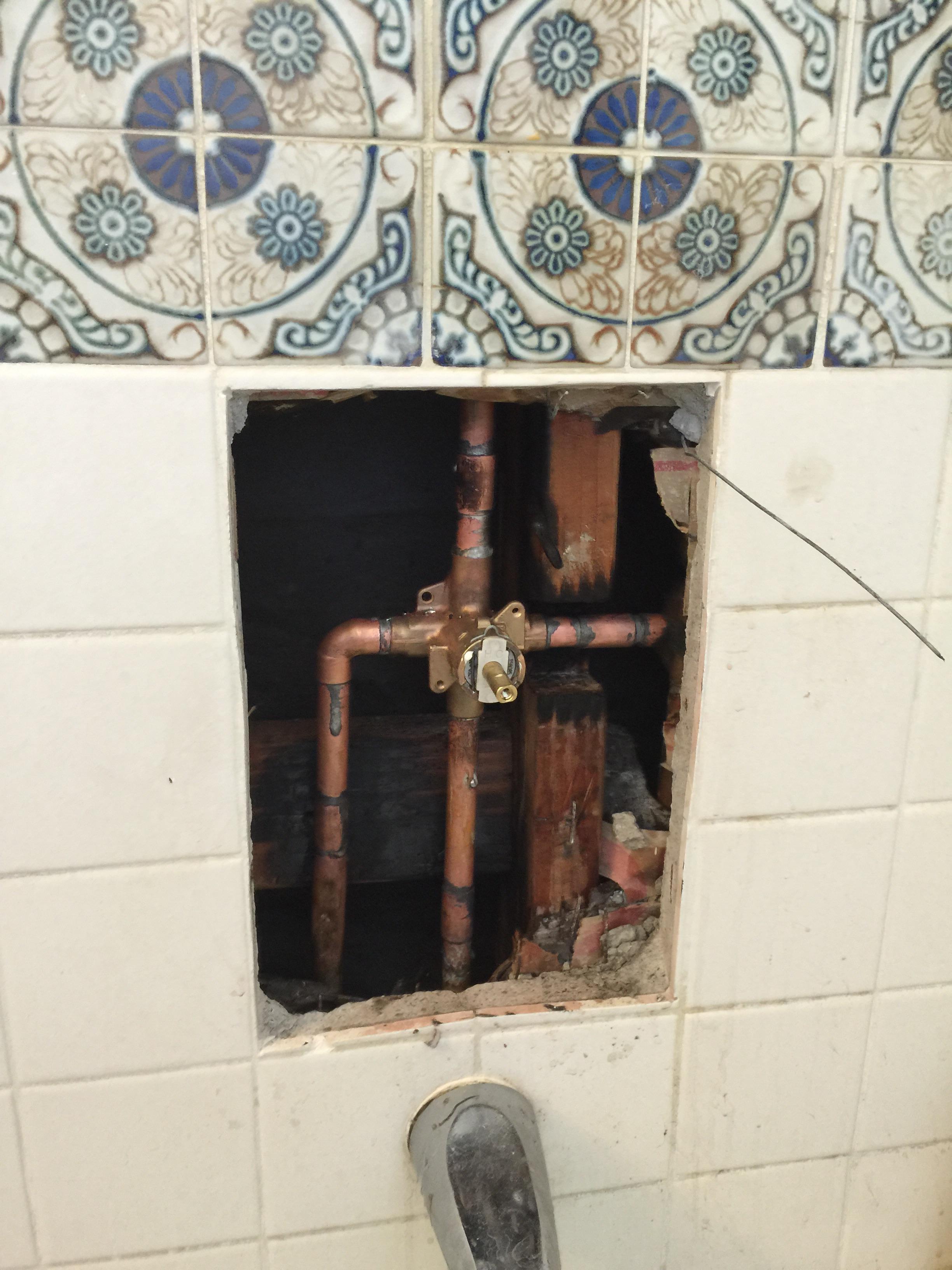 Cut tile and concrete wall to have access for shower valve replacement