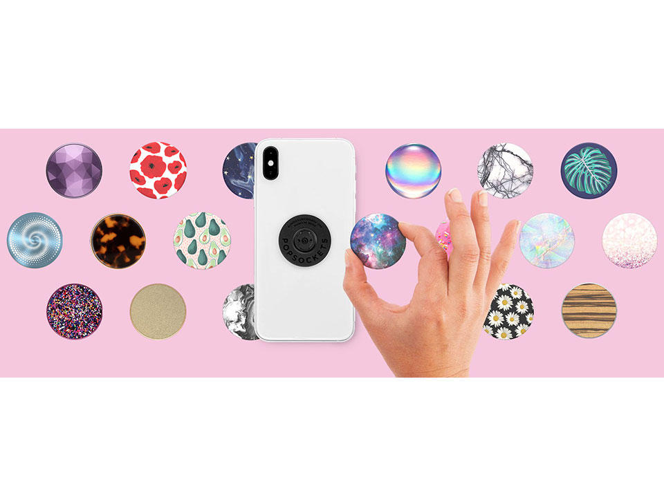 Assortment of PopSockets products arranged on a pink background