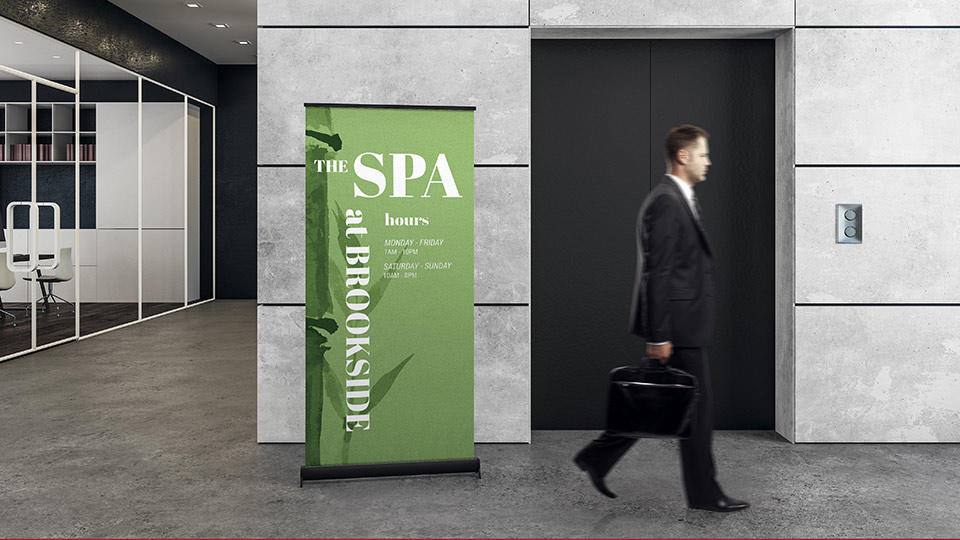 man walks by attractive pop-up banner for spa