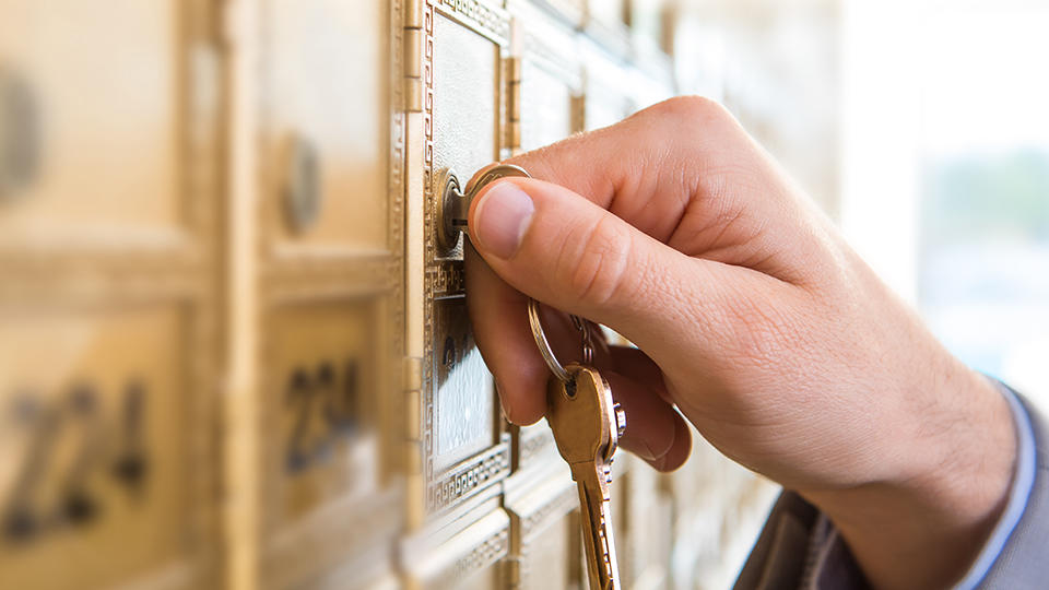 Close up photo of customer unlocking mailbox