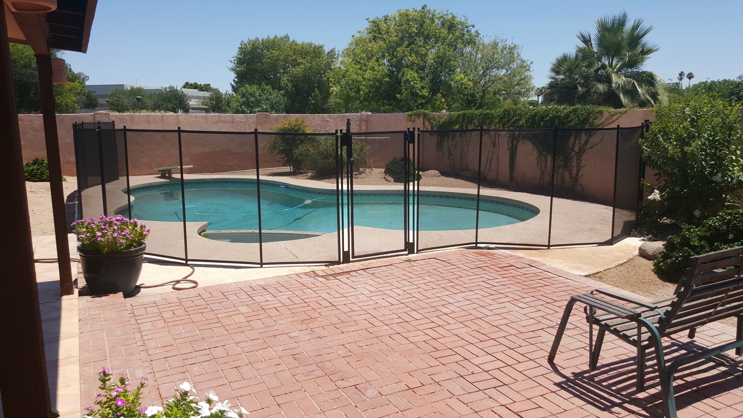 Katchakid removable pool safety fence with a self-latching gate.