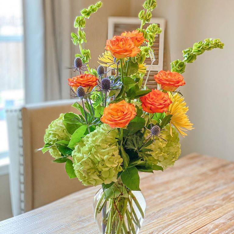 Modern Day Elegance - Orange Roses, Green Hydrangeas, Bells of Ireland with Thistle added makes a very Modern Flower Arrangement. Great for any occasion.