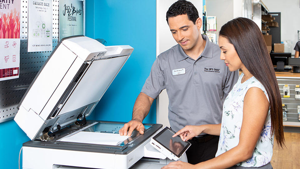 Employee assists customer at copier