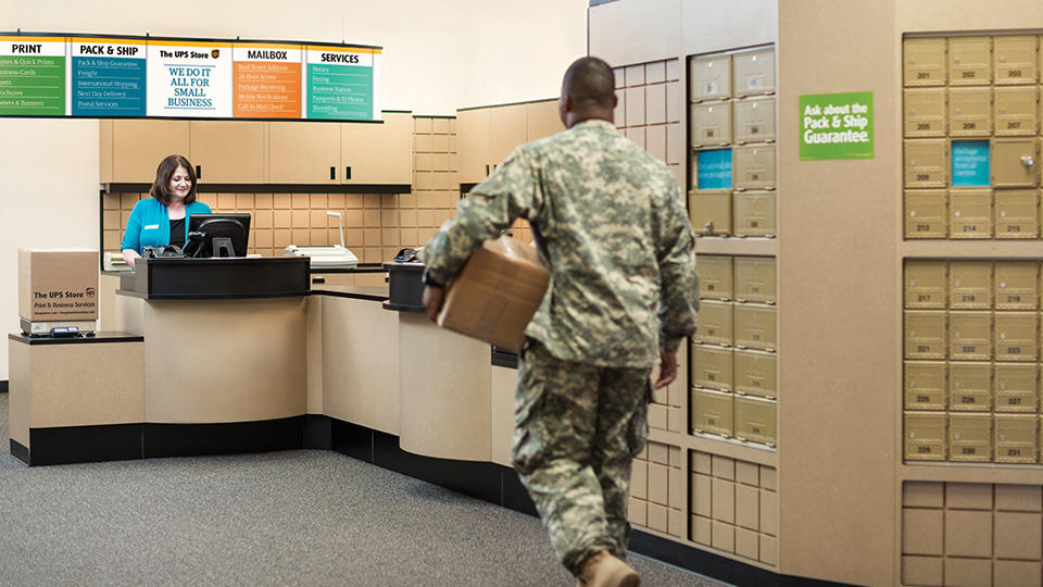 military officer dropping off package at the ups store