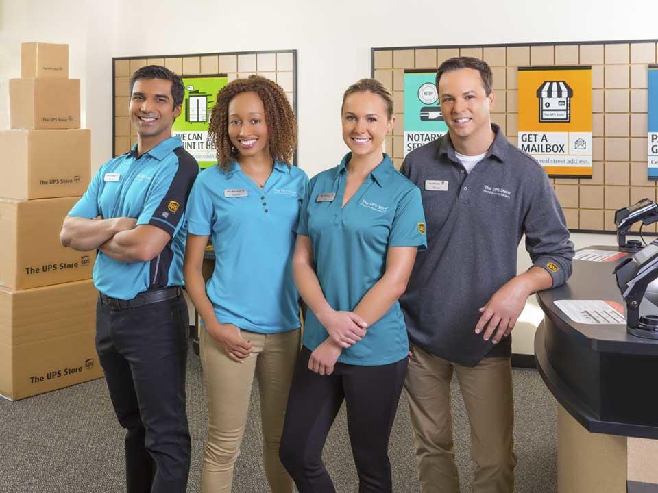 four UPS Store employees ready to welcome cutomers