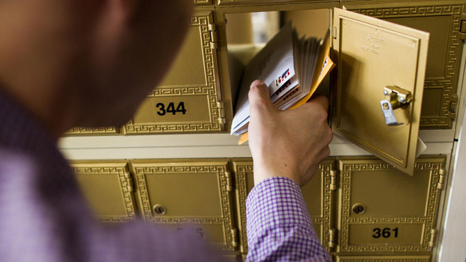 Close up of hand taking mail from mailbox