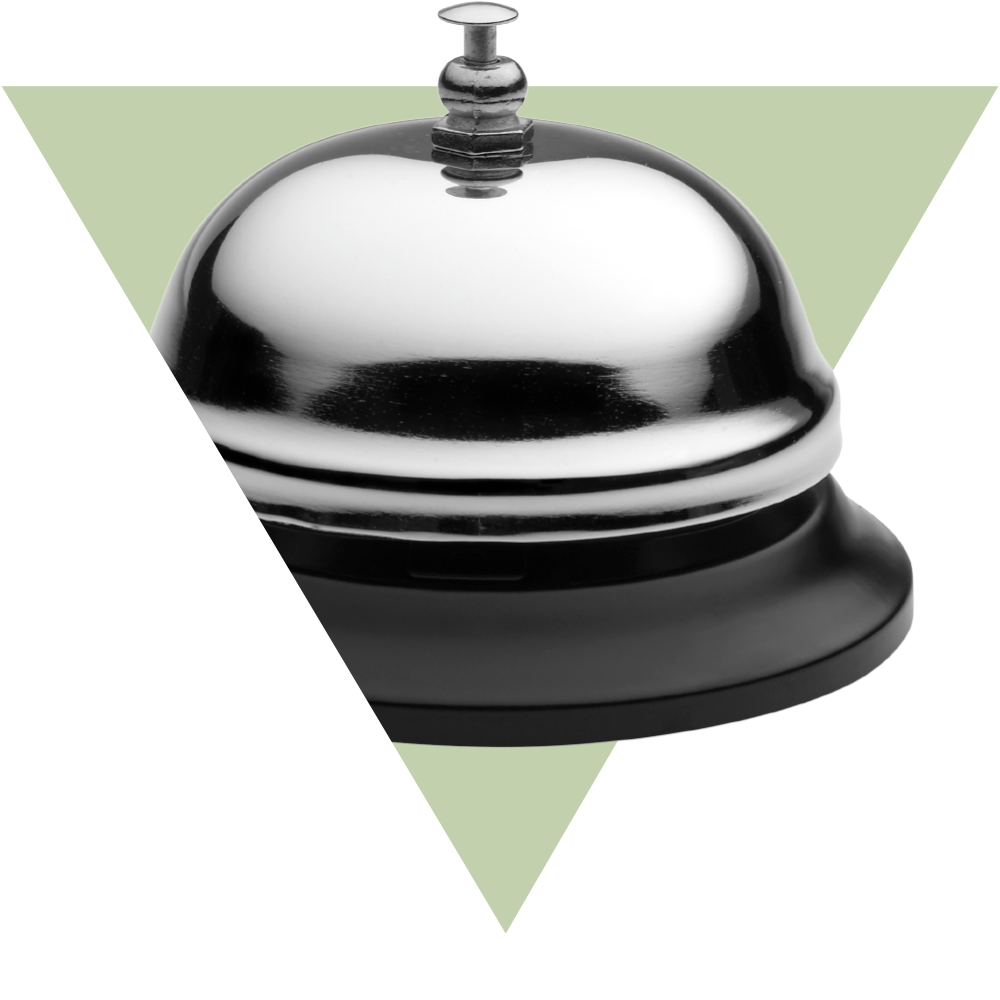 Partial view of a Hotel call bell on top of a upside down green triangle.