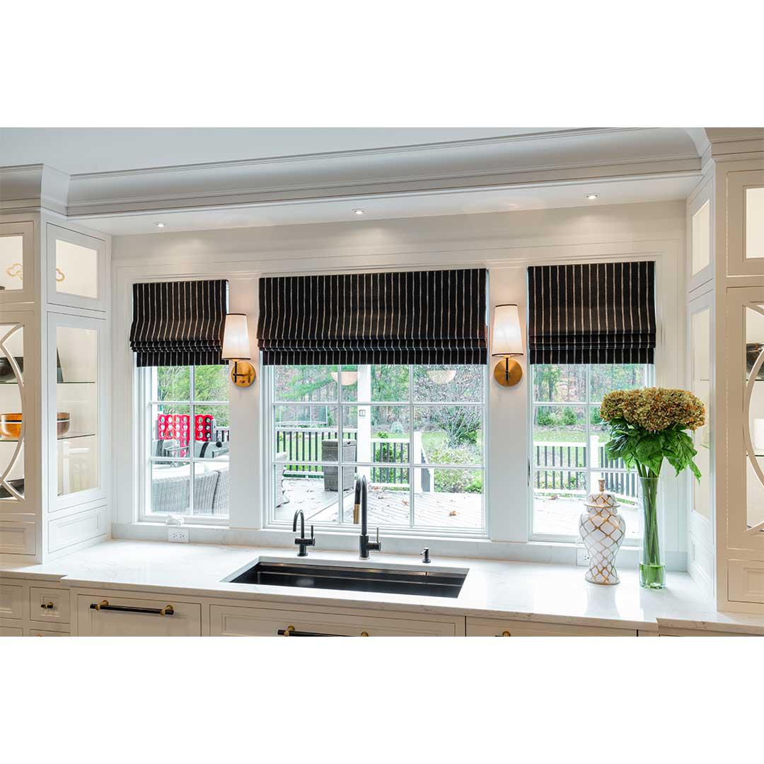Holiday baking is pure joy in a gorgeous kitchen like this one. The custom roman shades in a classic stripe add sophisticated style and stunning contrast to the all white kitchen. Let us help you find the perfect fabric for your home!