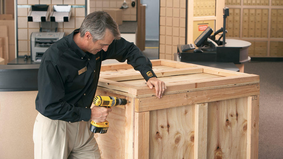 a The UPS Store associate building a custom shipping crate