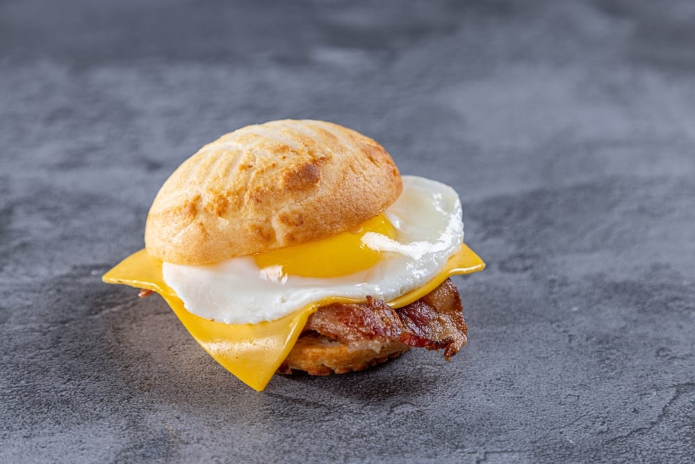 Huevos con tocineta, pandebono & queso Suizo