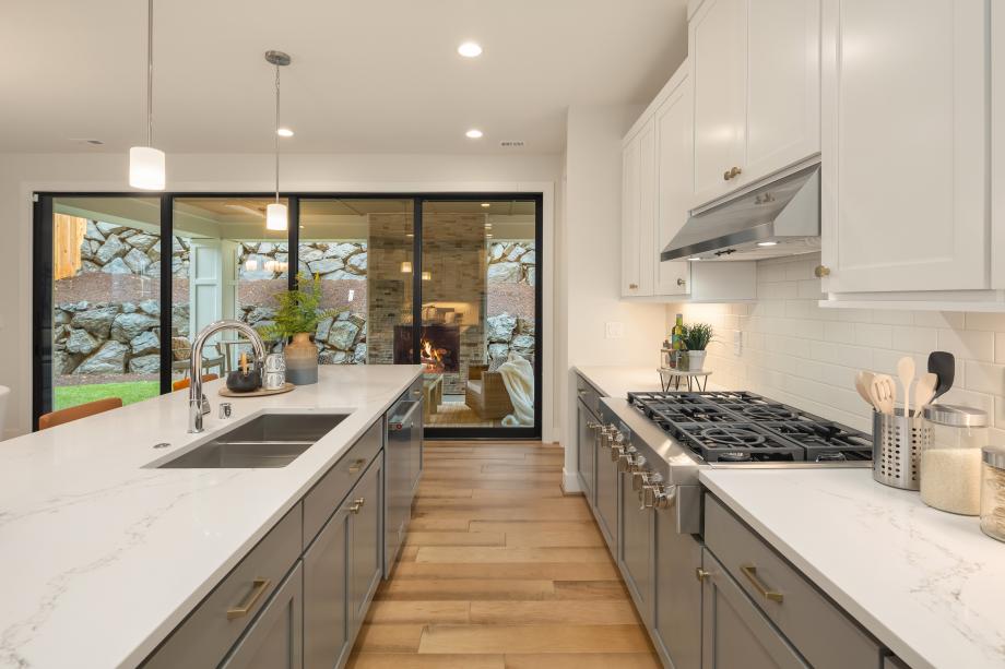 Stacking glass doors from the kitchen open to covered patio in the Anacortes home