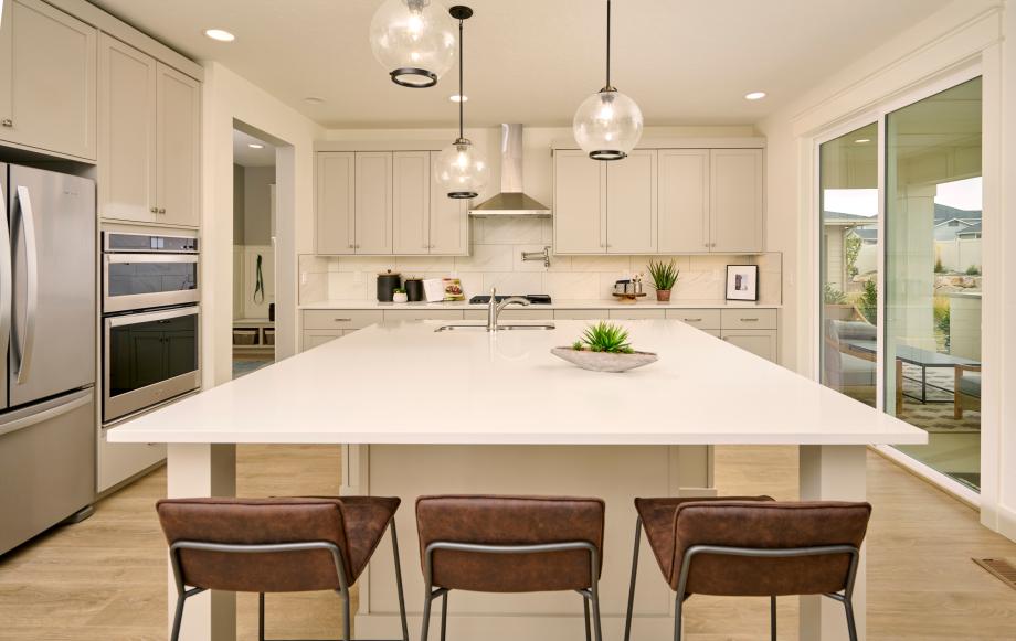 Open kitchen with large center island and striking creamy-grey cabinets