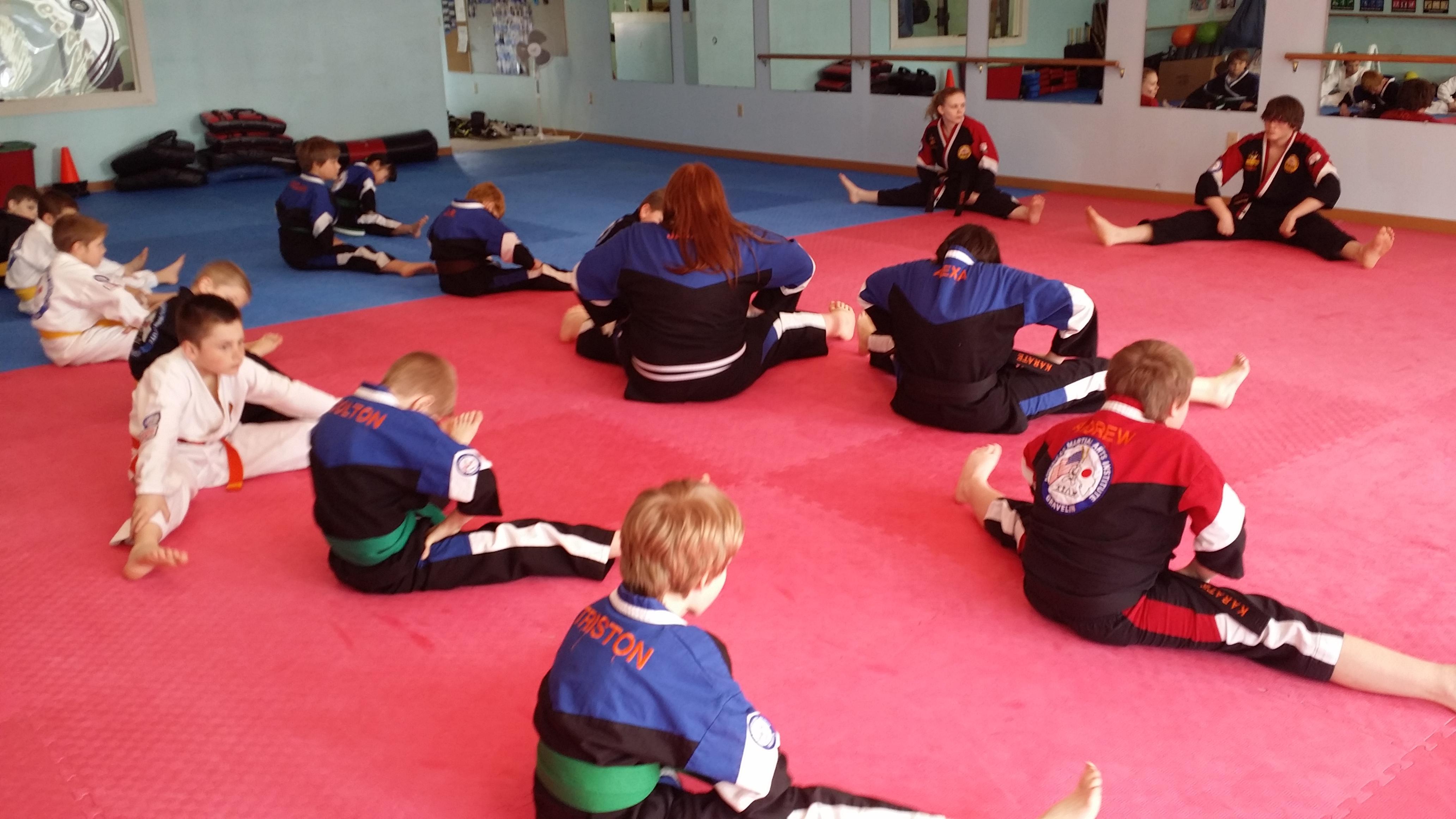 Roland Nulph and Kelly Salmon both 2nd degree Black Belts stretching out a Junior class at AMAI