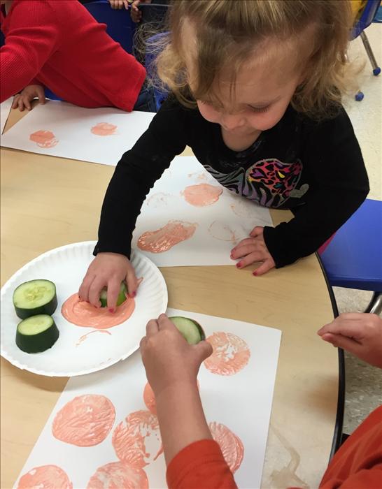 Toddlers painting with cucumbers