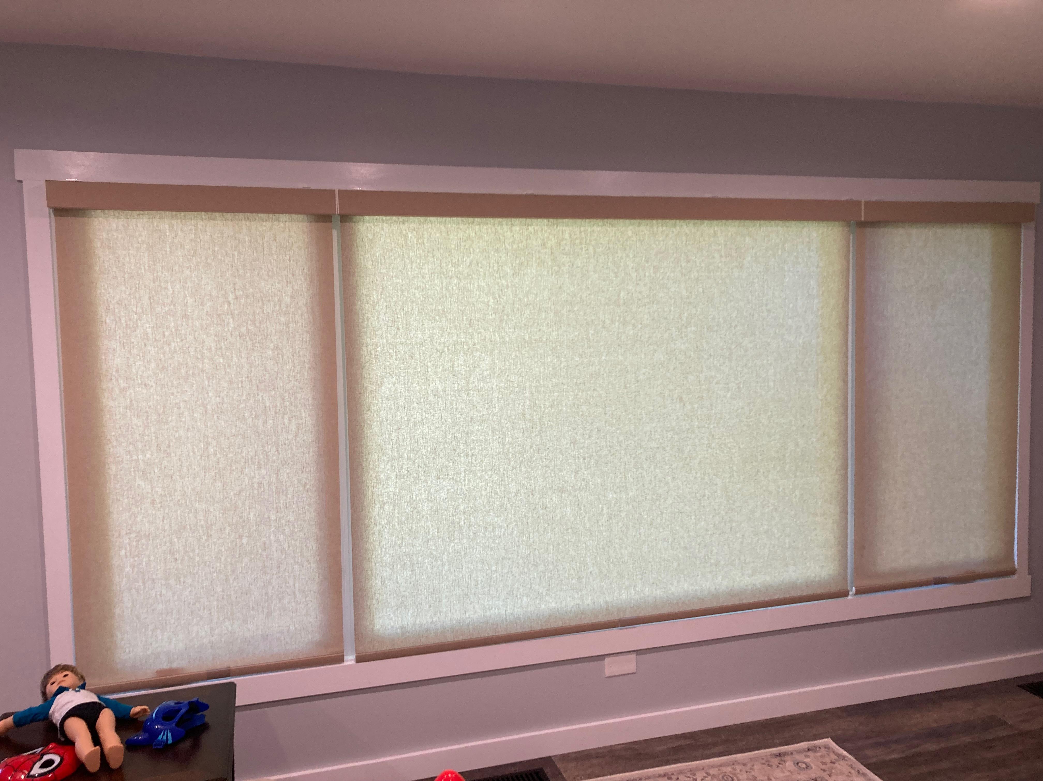 Light filtering roller shades in a living room window cordless with mating fabric wrapped cassettes.