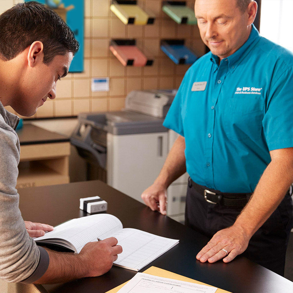 ups store associate assisting house account customer at counter