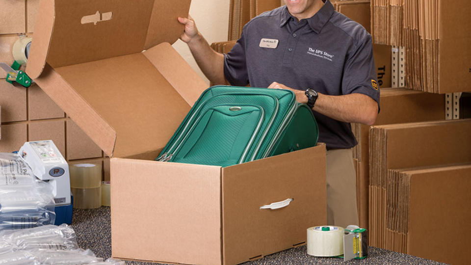 Employee packing luggage into box