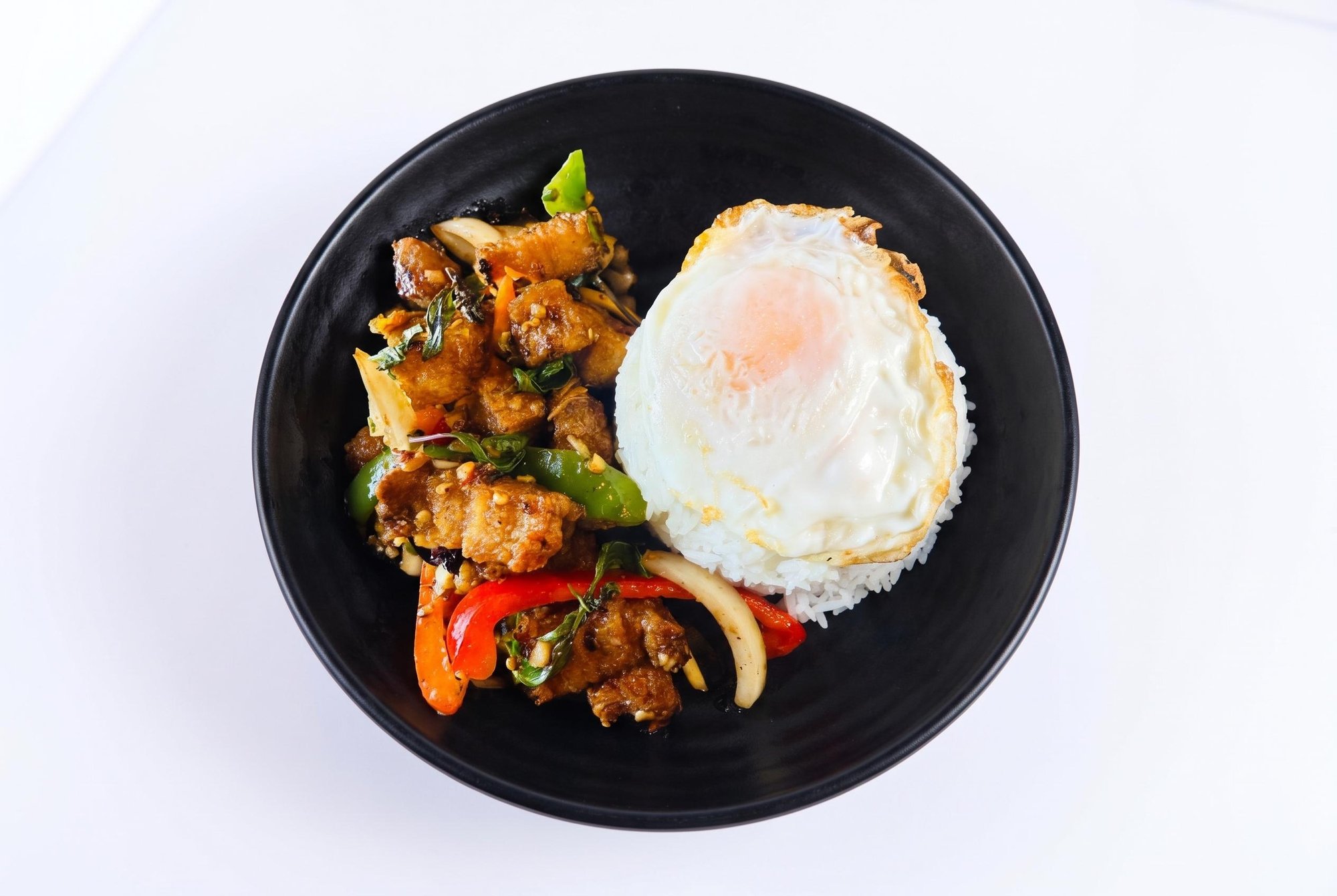 Crispy pork belly kra pow over rice w/fried egg