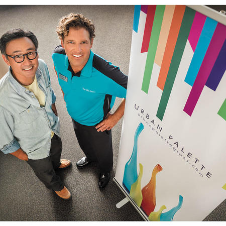 Business owner and The UPS Store employee standing by a printed banner