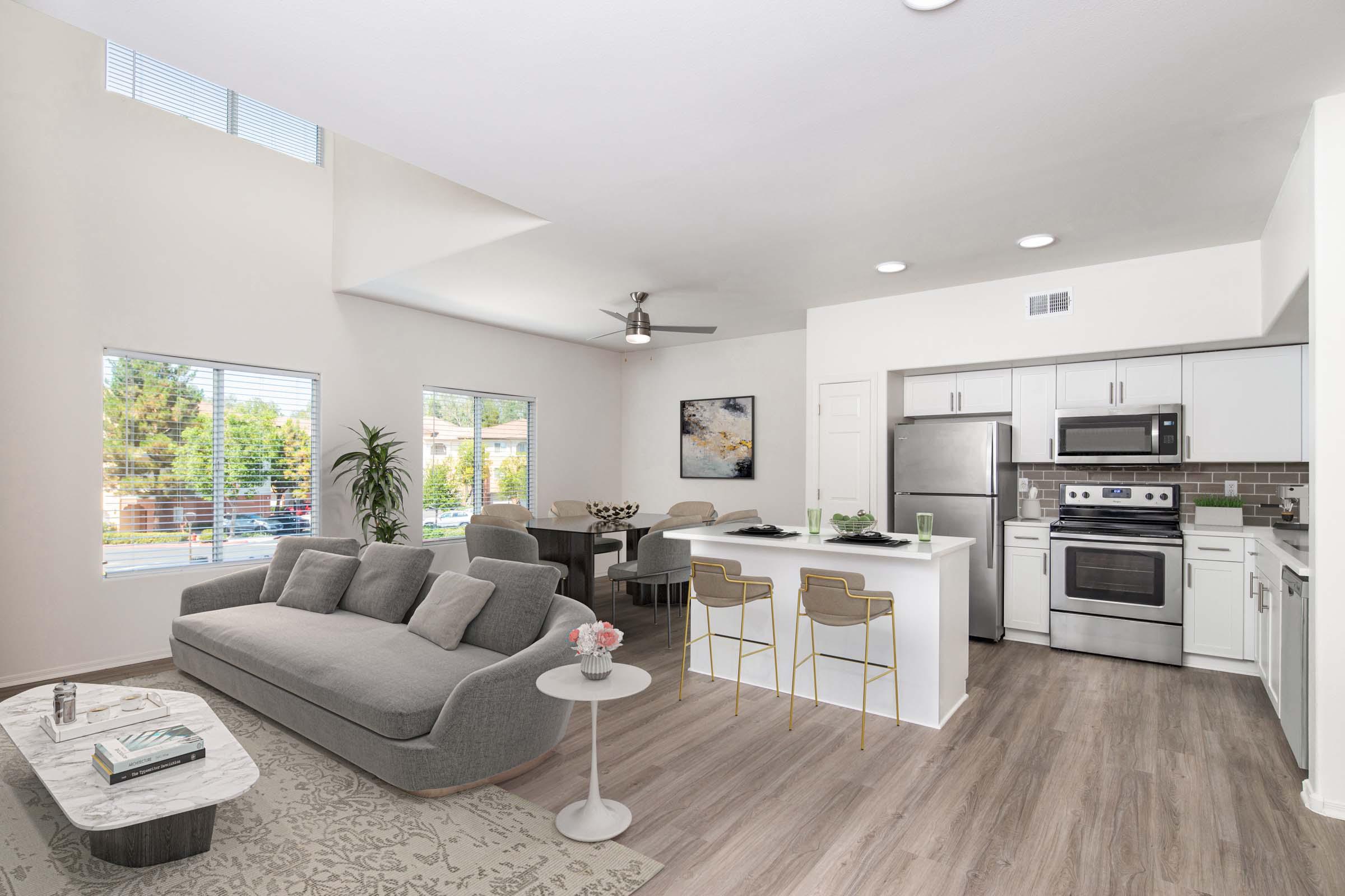 Townhome living and dining area near kitchen with stainless steel appliances, white quartz countertops, subway tile backsplash, and brushed nickel fixtures