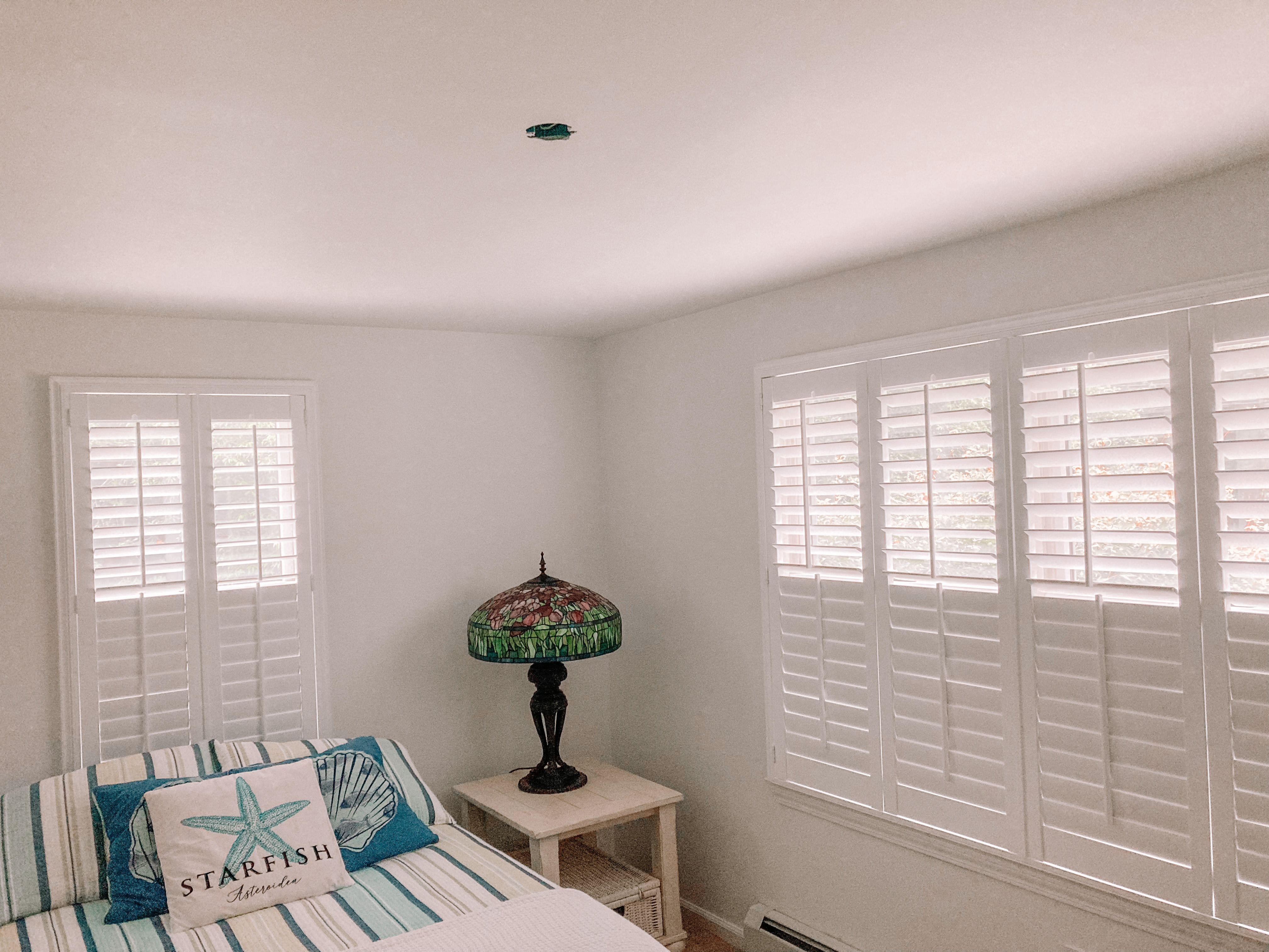 Shutters help to complete the beach vibe of this bedroom in Howell, NJ