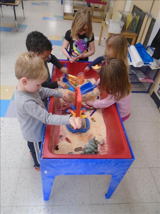 Our theme in Pre-K is Dinosaurs!!! Here is a group of our Pre-K class exploring and looking for fossils in the Science/Sensory table.