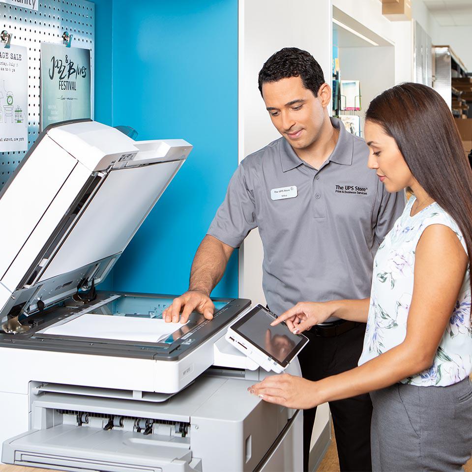 store associate helping customer make a copy inside The UPS Store