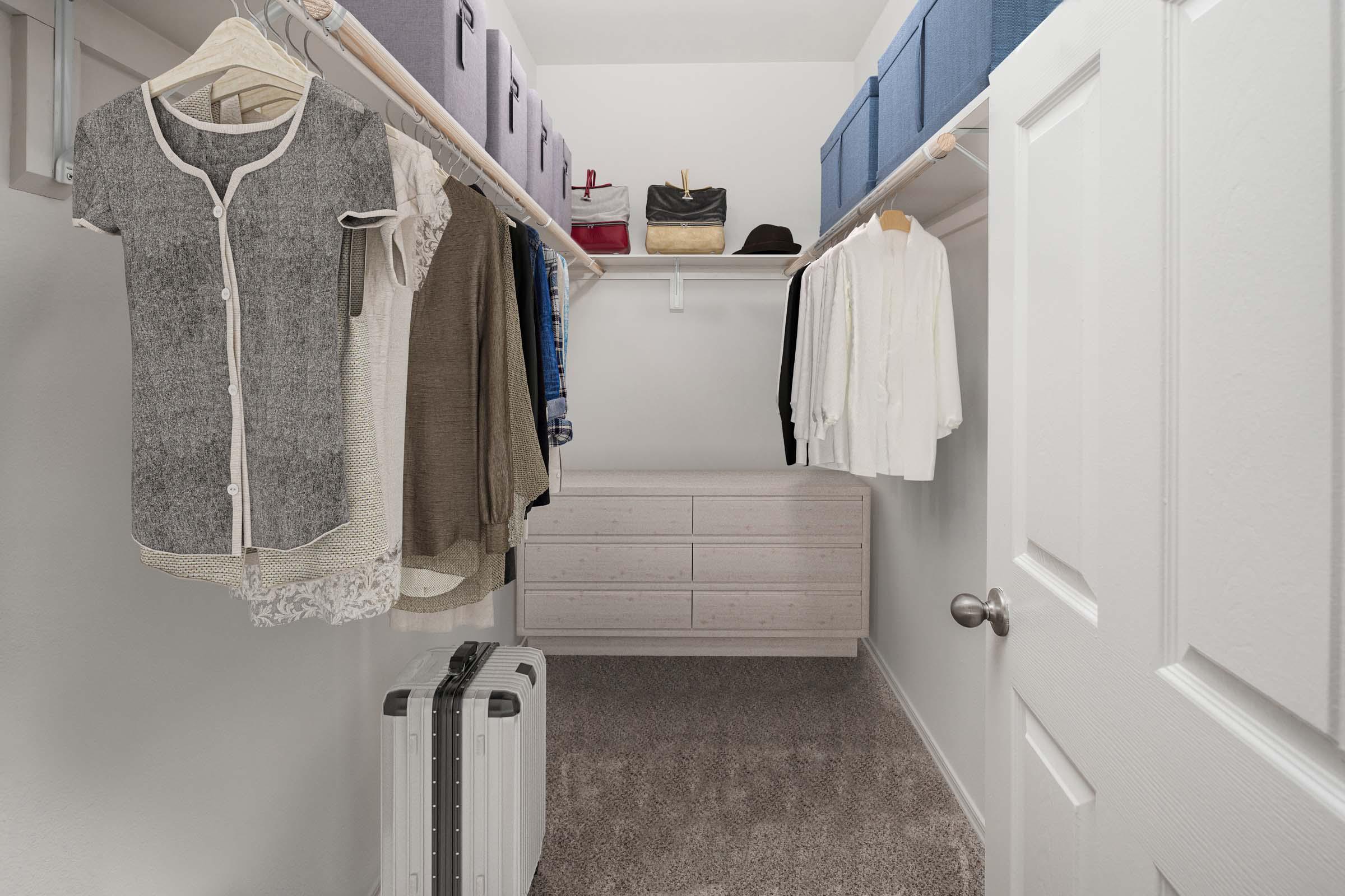 Walk-in closet with wooden shelves, rods and room for a dresser