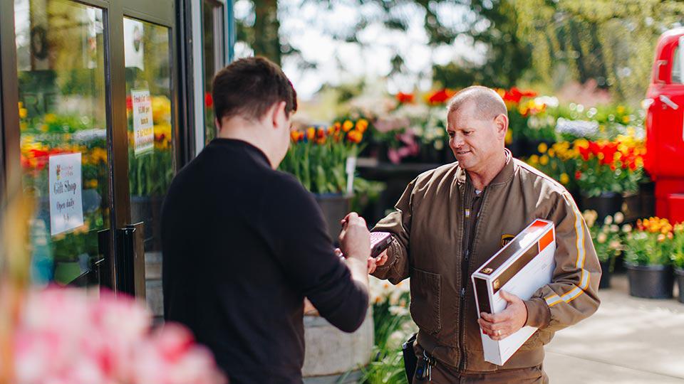 A florist signs for a delivery from a UPS driver