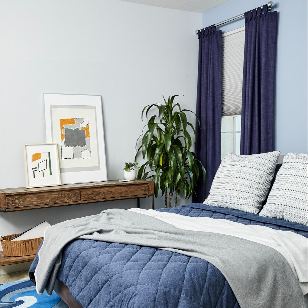 Want to add a pop of color to your windows but also want privacy? Pairing Enlightened Style Cellular Shades with Lafayette Custom Inspired Draperies allows you to have both! This bedroom has a wonderful pop of blue to complement the rest of the simple and stylish interior.  BudgetBlindsOfOwasso  Fre