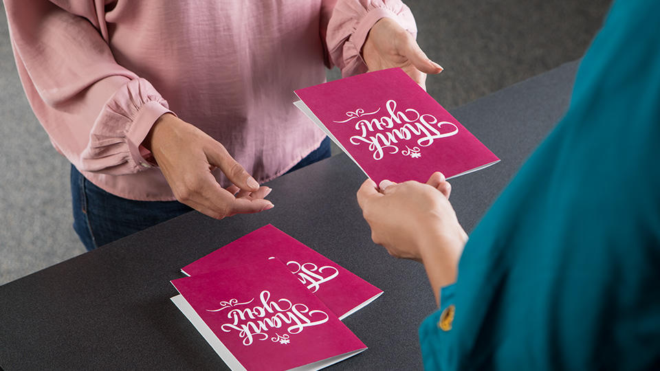 Employee handing thank you card to customer