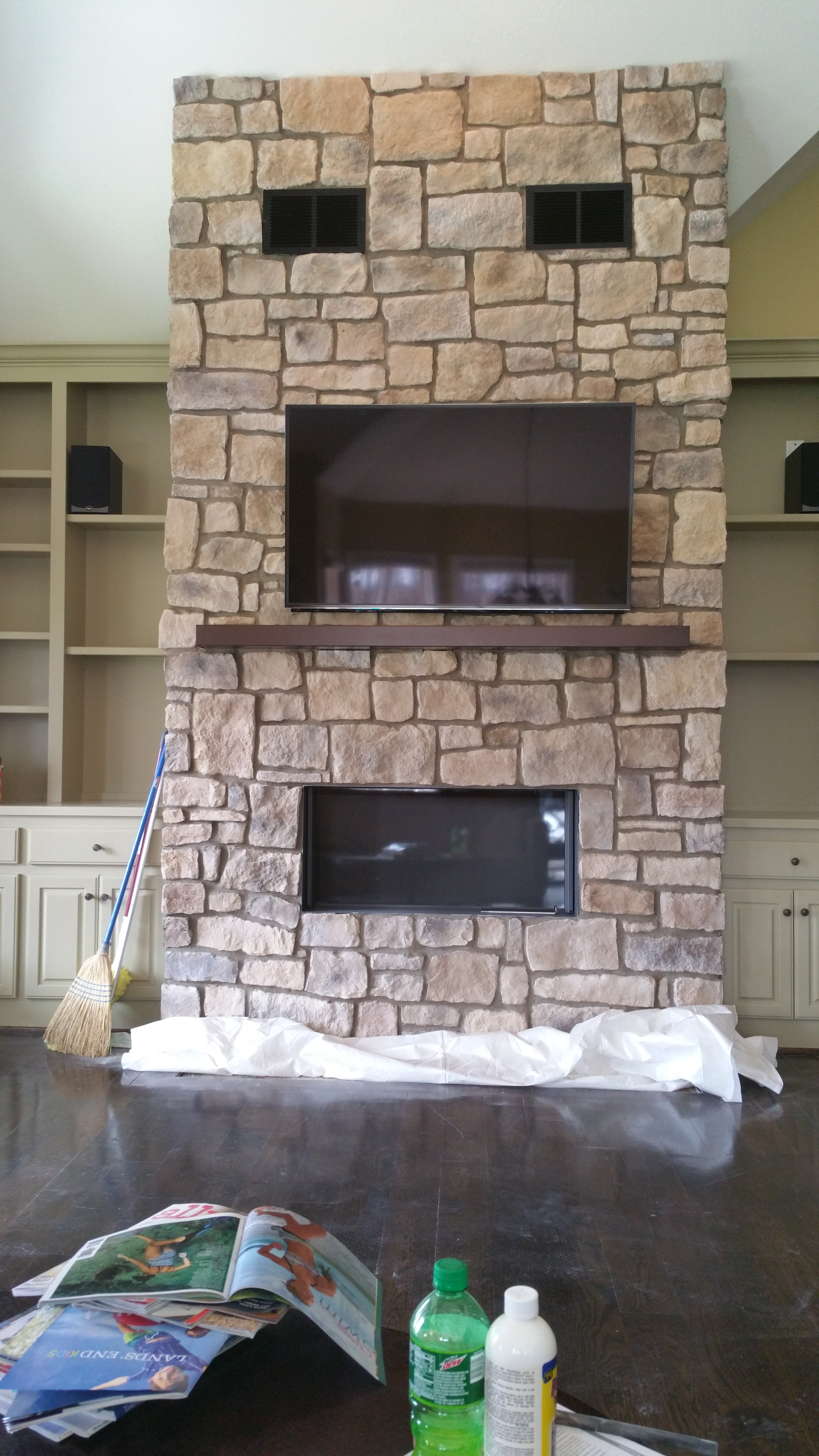 SO this is a wood burning fireplace that is sealed from the room with a glass door that raises up when you want to add to the fire. The heat radiates from the unit and also out the vents you see installed in the top of the stone. Non combustible mantel to protect the TV from any heat that the unit puts off.