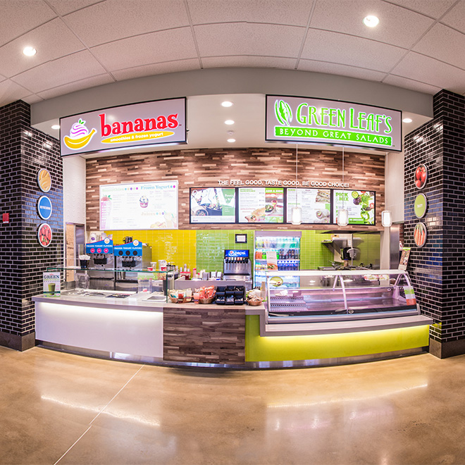 View of a Villa Restaurant Group location inside a mall, on the left is a "Bananas" smoothie shop and on the right is a  Green Leaf's Salad.