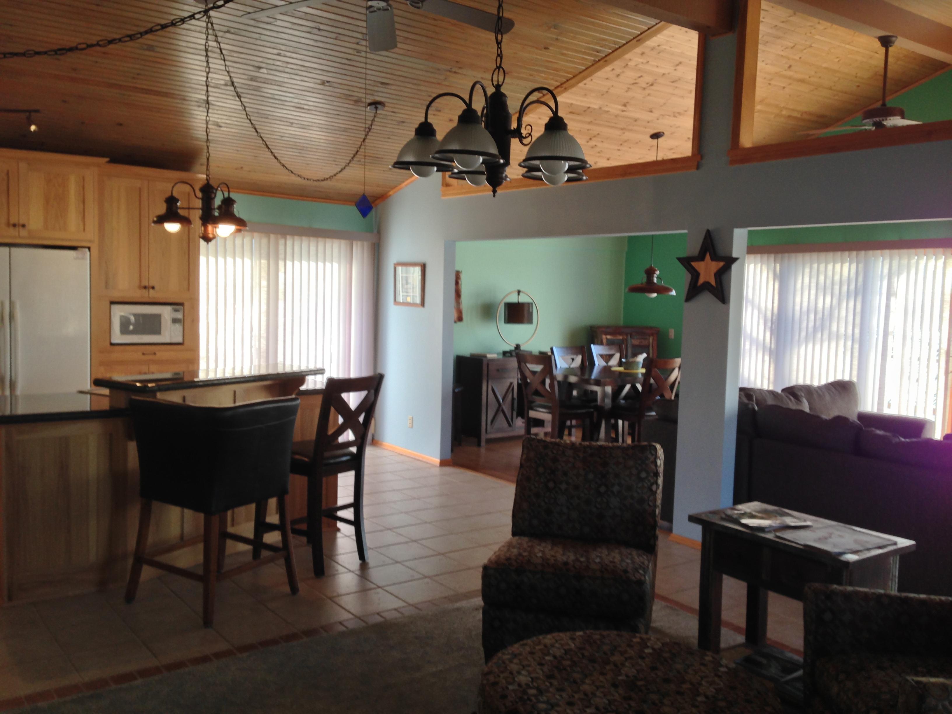 Family room with bar, TV and a Foosball game, fireplace(winter rentals) opens onto deck.