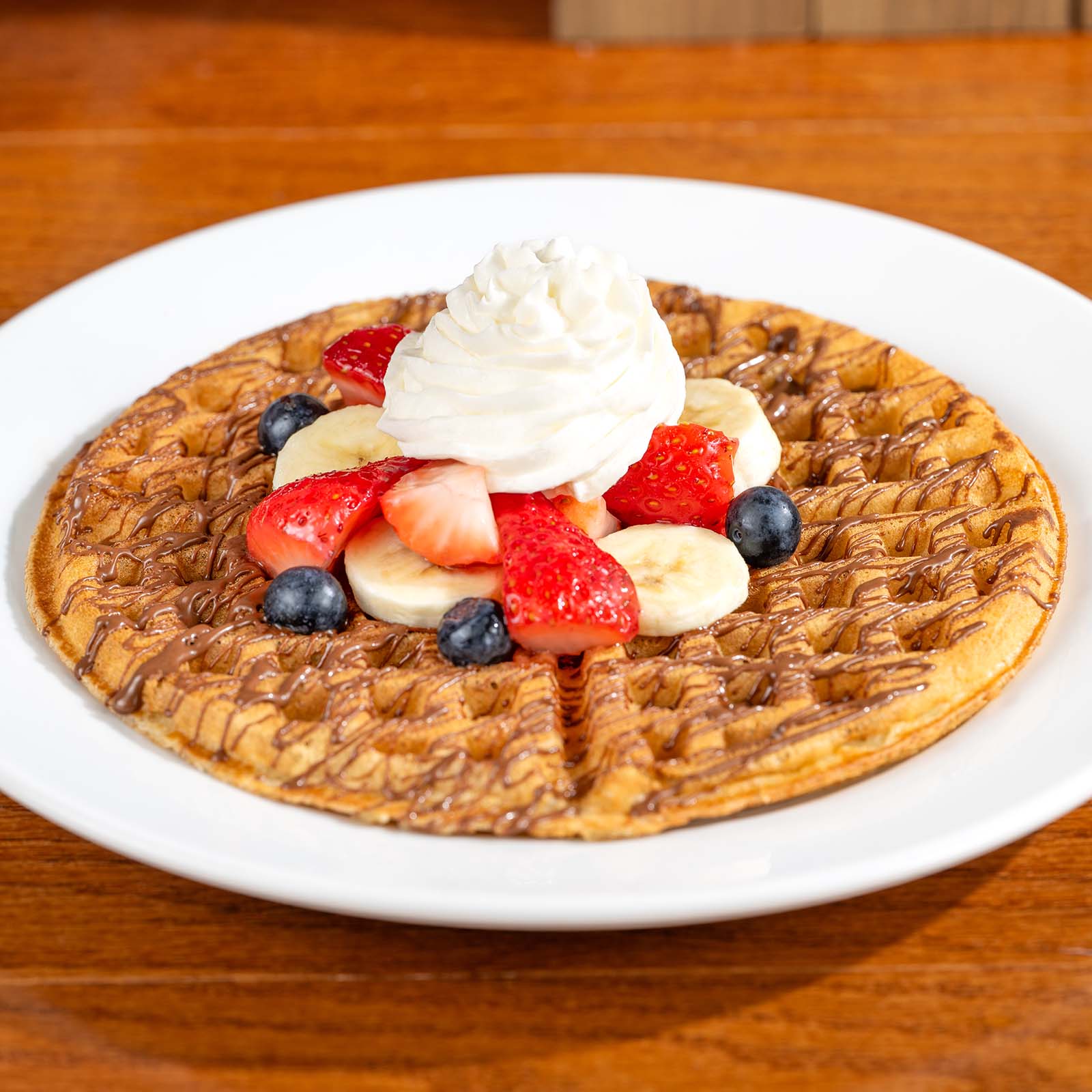 Waffle with Chocolate-Hazelnut Spread, Bananas, Berries, and Whipped Cream