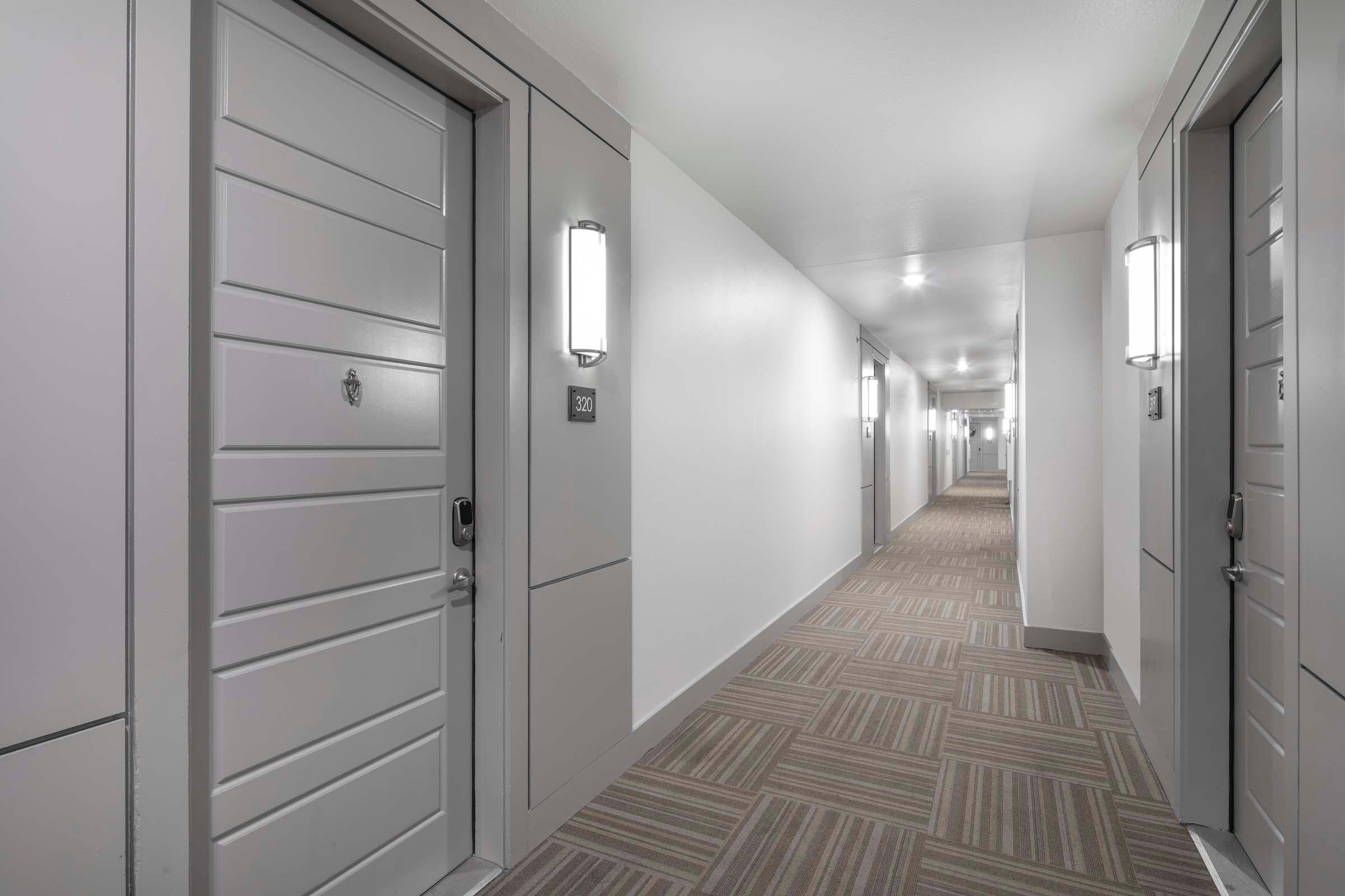 Third floor Villas side hallway with interior-facing front doors at Camden Greenville