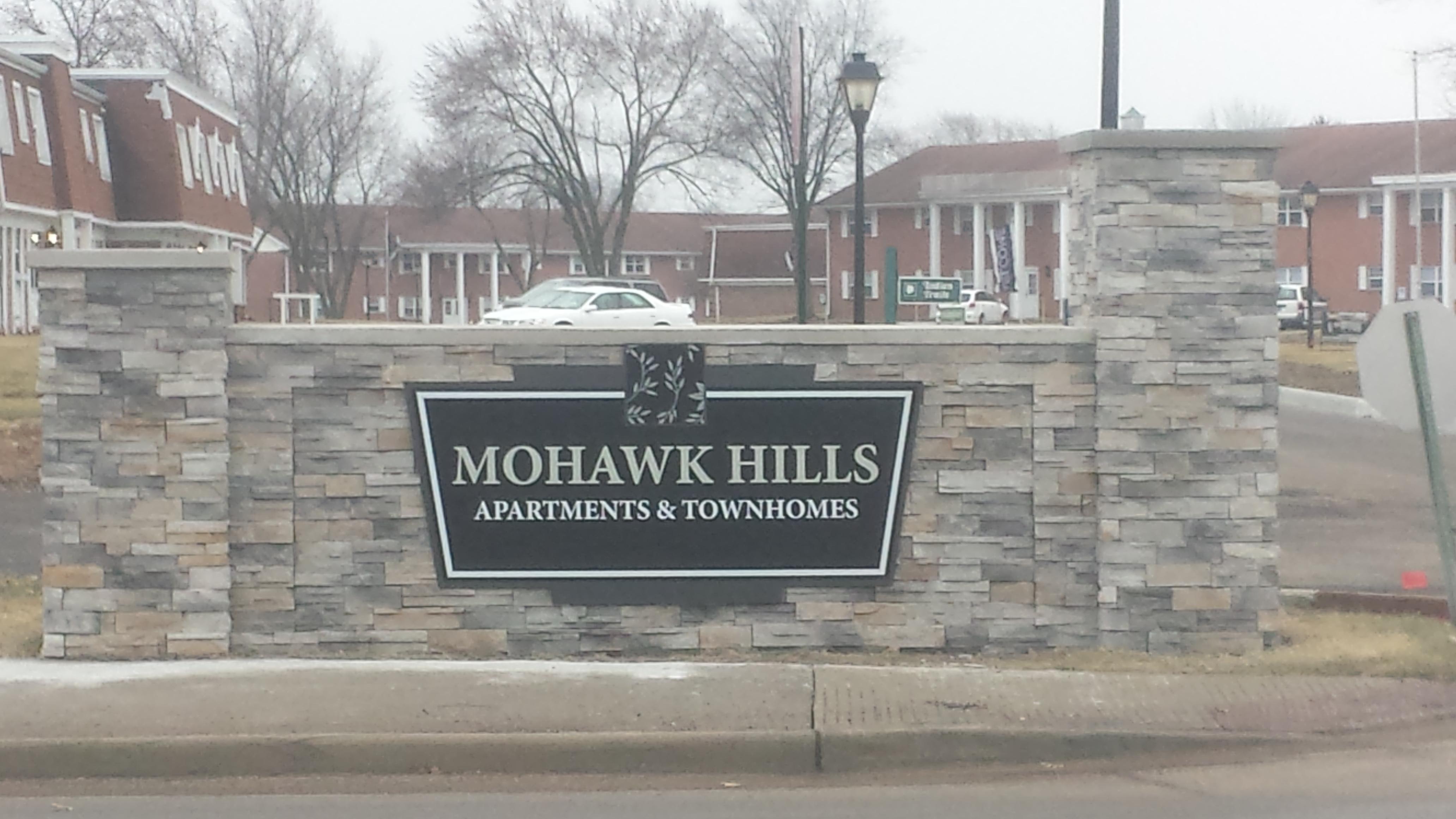 This sign is constructed of solid masonry with a manufactured stone veneer, and poured in place concrete caps 