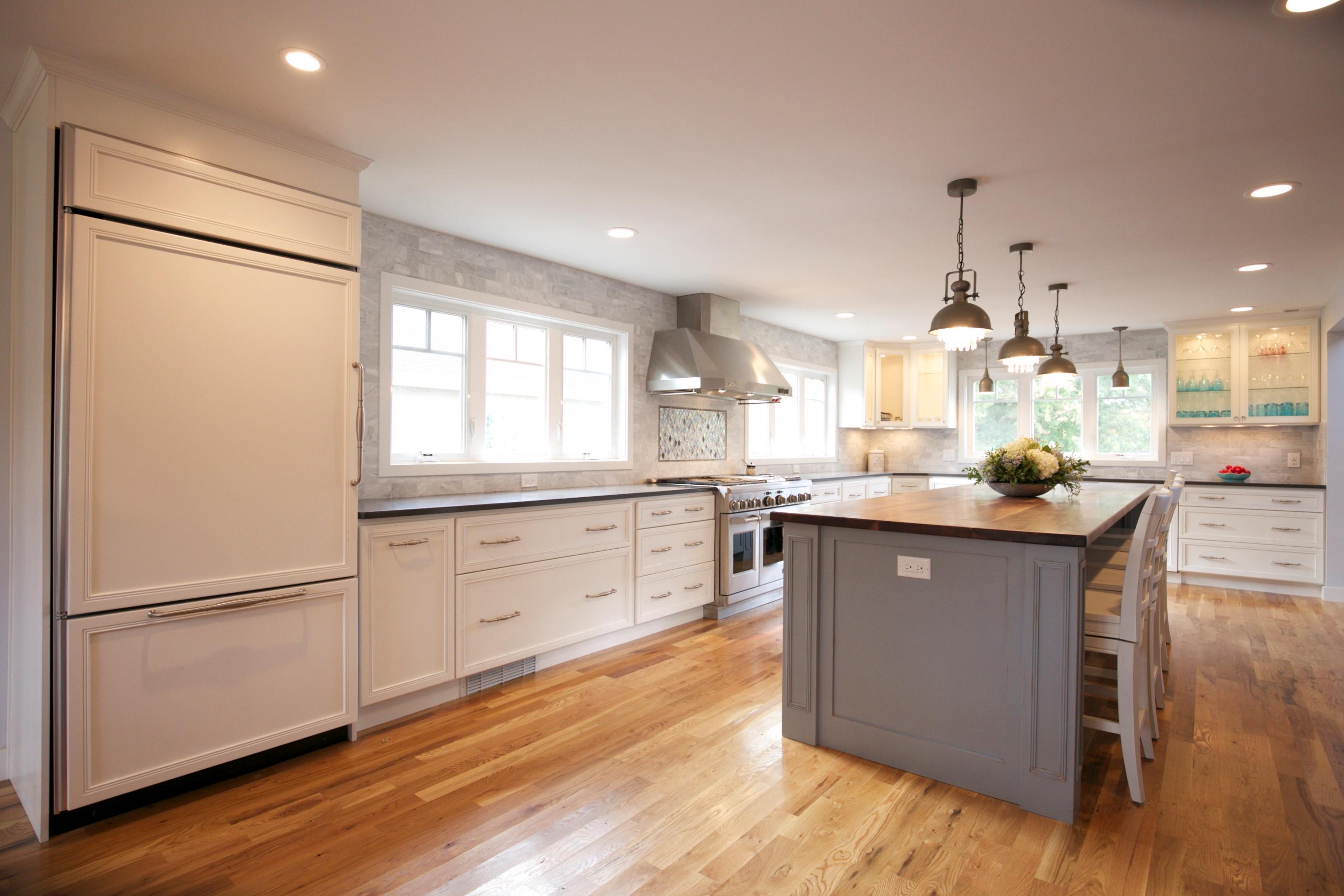 Shaker Style Kitchen Cabinets with Quartz countertop and Dark Walnut island top.  Marble tile backsplash.