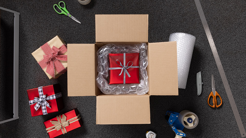 Wrapped gift inside The UPS Store box, with packing supplies scattered around the box.