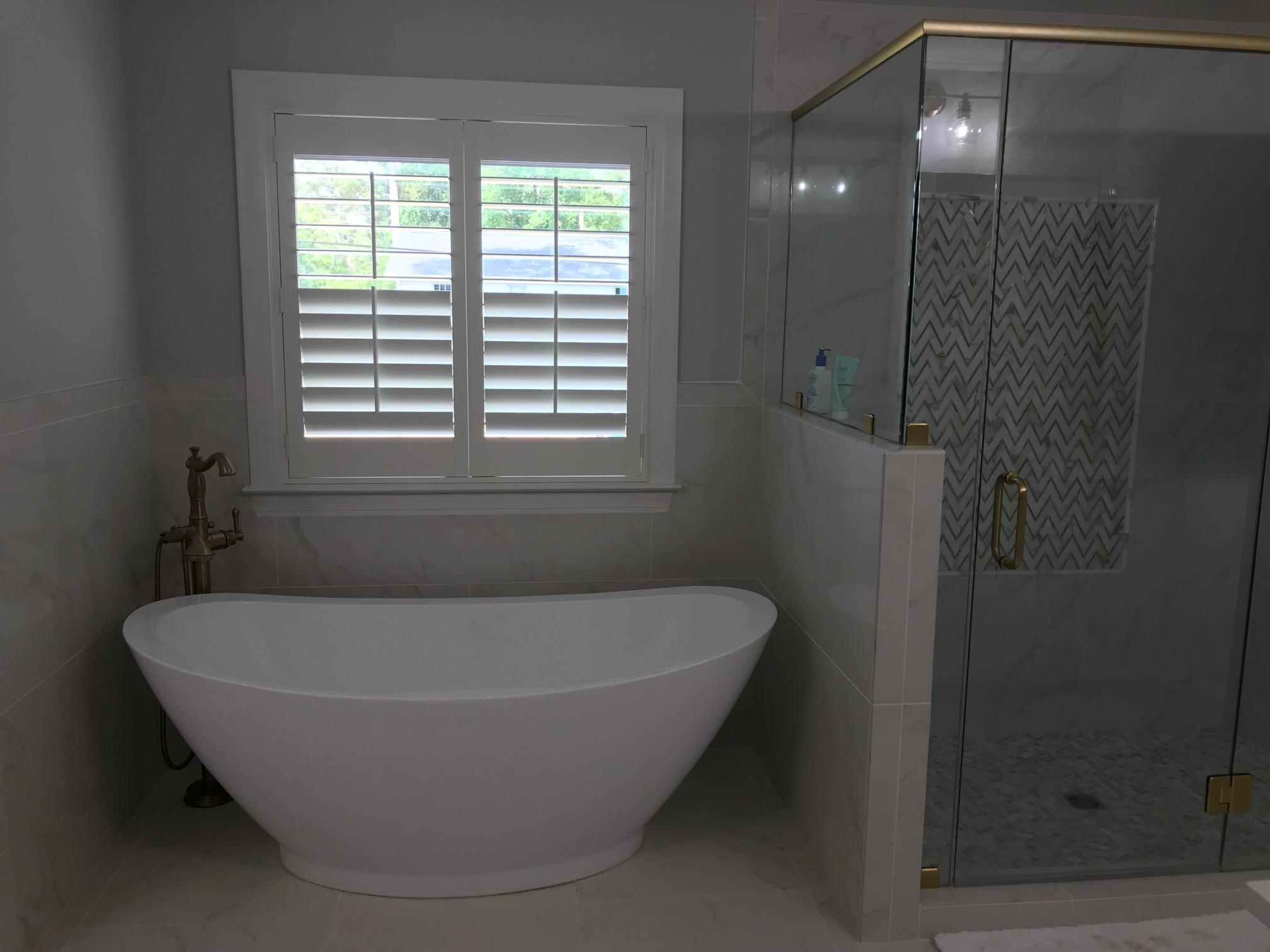 Can't go wrong with the privacy and classic look of Plantation Shutter over a beautiful bathtub