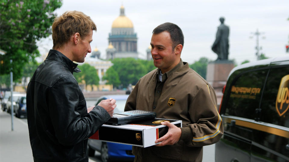 El conductor de UPS entrega un paquete a un cliente