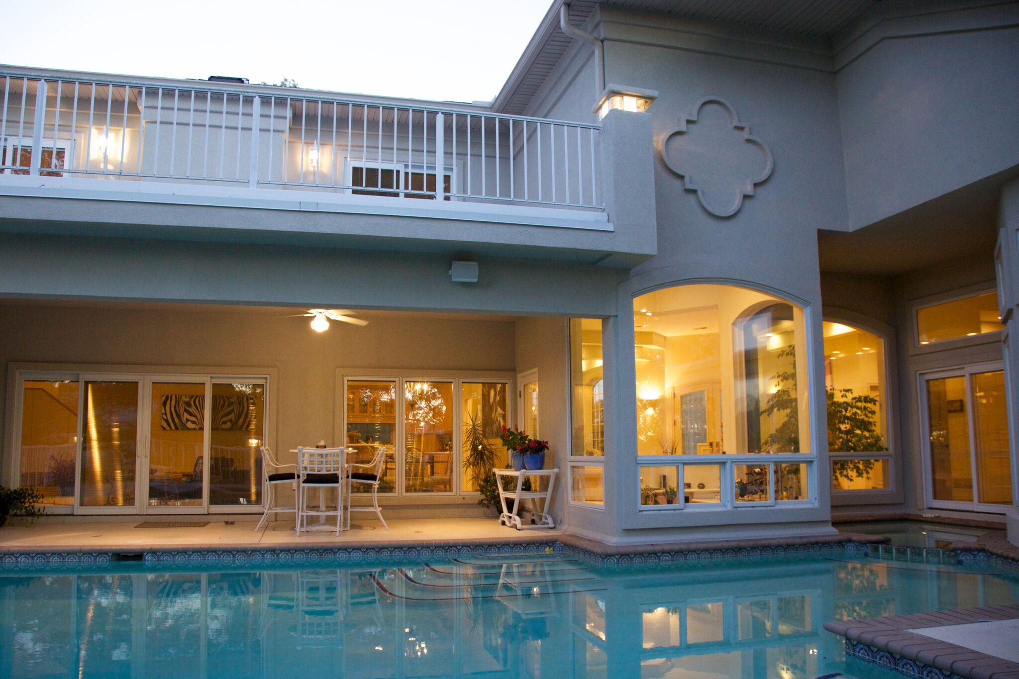 Covered patio overlooks the sparking swimming pool. 