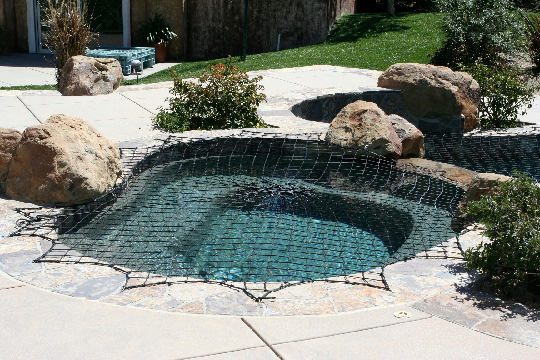 A Katchakid pool safety net cover for an inground spa.
