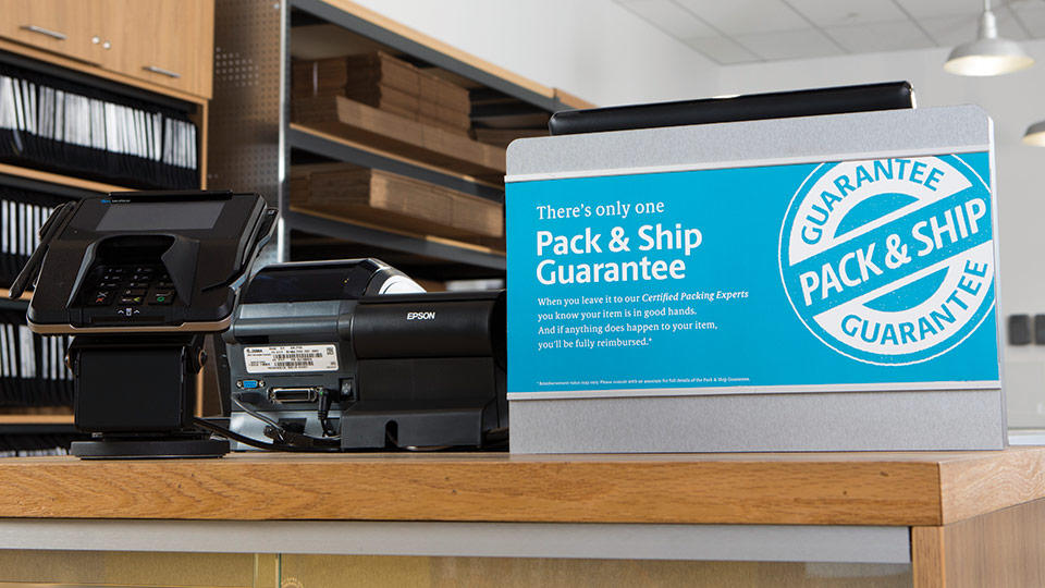 Pack and Ship Guarantee placard on counter